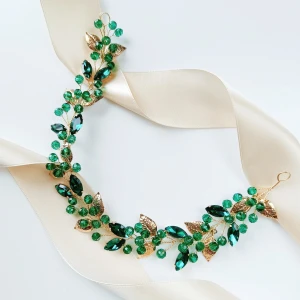 Zlatá ozdobná větvička do vlasů zelená s lístky a krystaly